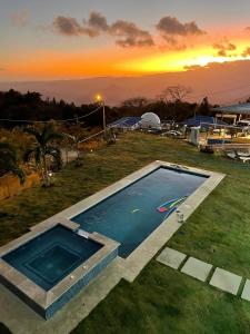 a swimming pool with a sunset in the background at Casa Blanca de Chicá in Chicá