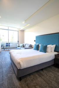 a bedroom with a large bed with a blue headboard at Mercure Centro Port Macquarie in Port Macquarie