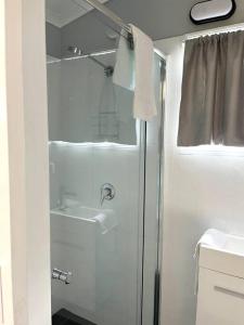 baño blanco con ducha y lavamanos en The Villas - Hervey Bay - 2 separate villas, en Urangan
