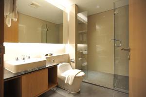 a bathroom with a toilet and a sink and a shower at Midtown Residence Surabaya in Surabaya