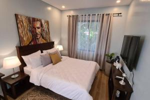 Schlafzimmer mit einem Bett mit Wandgemälde in der Unterkunft The Great Molave SUPERIOR ROOM in Cavite