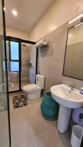 ein Badezimmer mit einem Waschbecken, einem WC und einem Spiegel in der Unterkunft The Great Molave SUPERIOR ROOM in Cavite