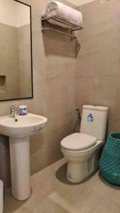 ein Badezimmer mit einem weißen WC und einem Waschbecken in der Unterkunft The Great Molave SUPERIOR ROOM in Cavite