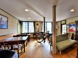 茅野的住宿－車山高原悠萊旅館，客厅配有桌子和自行车