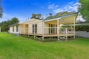a yellow modular house with a large yard at Dolphin Drift 29 Dolphin Avenue in Carrickalinga