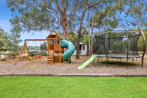 a playground with a slide and a swing at A home amongst the gum trees in Torquay