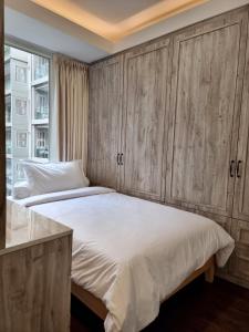 a bedroom with a large bed with wooden cabinets at New! Luxury Landmark Residence Apartment 2+1BR 96m in Bandung