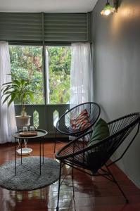 een kamer met 2 stoelen, een tafel en een raam bij Inn Oon Villa in Chiang Mai