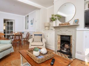a living room with a fireplace and a mirror at Juniper Cottage in Dartmouth