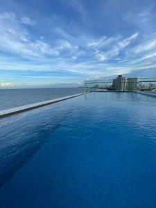 a swimming pool with the ocean in the background at De Lamour Hotel in Da Nang