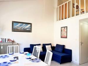 une salle à manger avec une table et des chaises bleues dans l'établissement Appartement Le Lavandou, 1 pièce, 4 personnes - FR-1-251-491, au Lavandou