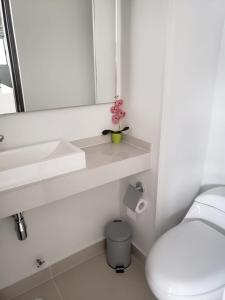 uma casa de banho branca com um WC e um espelho. em Hermoso apartamento para estrenar en Valle de Lili em Nariño