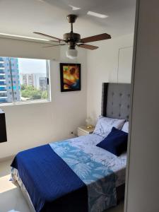 um quarto com uma cama azul e uma ventoinha de tecto em Hermoso apartamento para estrenar en Valle de Lili em Nariño