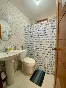 a bathroom with a white toilet and a sink at MyGuide Travellers Inn in Coron