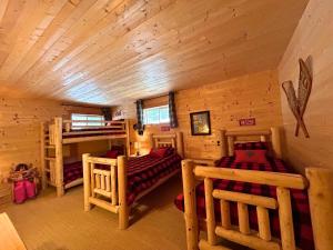 a log cabin with two beds and a loft at WAPITI - Chalets de Môh - Jacuzzi in La Malbaie