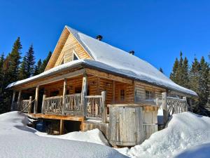 a log cabin in the snow with snow at WAPITI - Chalets de Môh - Jacuzzi in La Malbaie
