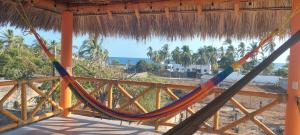 una hamaca en un porche con vistas al océano en Casa de Playa Coco'z, en Coyuca de Benítez