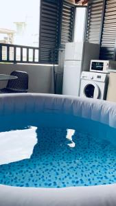 a pool in a room with a washing machine at Cosy suite centre ville avec bain à remous in Pointe-à-Pitre