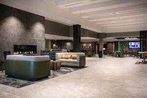 a lobby with a fireplace and couches and tables at West Des Moines Marriott in West Des Moines