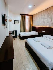 ein Hotelzimmer mit 2 Betten und einem TV in der Unterkunft Bamboo Garden Bussiness Inn in Dipolog City