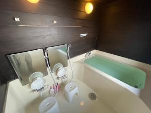 ein Badezimmer mit einer Badewanne, einem WC und einem Waschbecken in der Unterkunft Rusutsu Pension Clydesdale in Rusutsu