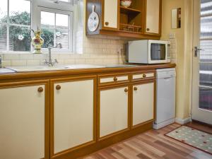 eine Küche mit einer Spüle und einer Mikrowelle in der Unterkunft East View in Shouldham