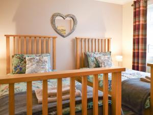 a bedroom with two beds and a heart mirror on the wall at East View in Shouldham
