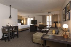 um quarto de hotel com uma cama e uma sala de estar em Residence Inn Durango Downtown em Durango