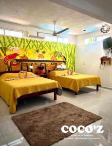 1 dormitorio con 2 camas con mantas amarillas y alfombra en Casa de Playa Coco'z, en Coyuca de Benítez