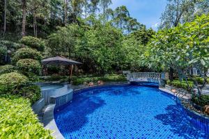 una piscina en un patio con sombrilla en Good View Hotel Tangxia - 15 mins drive from Dongguan South Railway Station en Dongguan