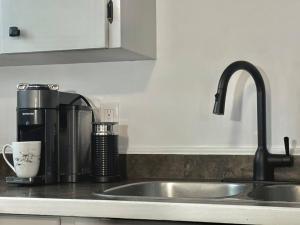 a kitchen counter with a sink and a coffee maker at Central Penticton. Alongside KVR Trail. Freshly Renovated. Pet Friendly. in Penticton