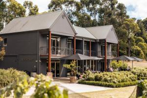 una casa negra con sombrillas delante en Quattro at Mantons Creek, en Red Hill South