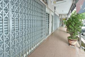 un couloir d'un bâtiment avec des plantes en pot dans l'établissement OYO 90626 Hotel Ezzyhome Johor Jaya, à Johor Bahru