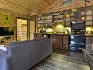 a living room with a couch and a kitchen at WOODY - Chalets de Môh in La Malbaie