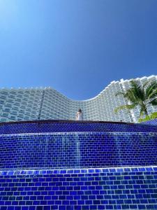 Ein Mann steht auf einem Gebäude mit blauen Fliesen. in der Unterkunft Sea Moon Cam Ranh Beach House in Cam Ranh