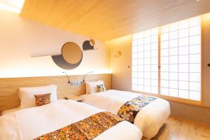 a bedroom with two beds and a window at Higashiyama Hills in Kyoto