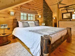 1 dormitorio con 1 cama grande en una cabaña de madera en BIGFOOT - Chalets de Môh - Jacuzzi, en La Malbaie