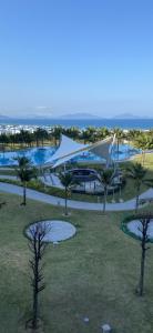 um resort com piscina e palmeiras em Sea Moon Cam Ranh Beach House em Cam Ranh