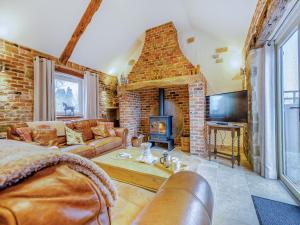 ein Wohnzimmer mit einem Sofa und einem Kamin in der Unterkunft The Old Granary in Cumberworth