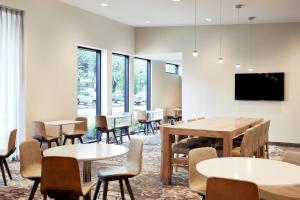 uma sala de espera com mesas e cadeiras e uma televisão de ecrã plano em Residence Inn By Marriott Dallas By The Galleria em Dallas