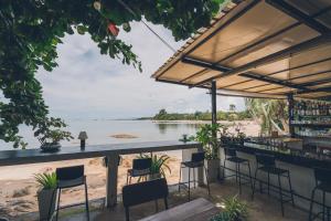 a bar with chairs and a view of the beach at Chill Inn Lamai Hostel & Beach Cafe in Koh Samui 
