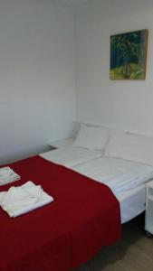 1 dormitorio con 1 cama con manta roja en Hostal Cubelles, en Cubelles