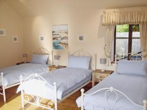 a bedroom with two beds and a window at Doves Barn in Needham Market