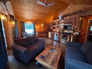 a living room with a couch and a table in a cabin at HUSKY - Chalets de Môh - Jacuzzi in La Malbaie