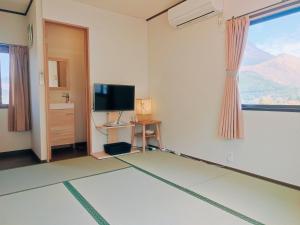 a room with a television and a room with a view at Yufuin Sunday in Yufuin