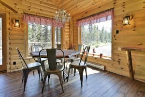 uma sala de jantar com uma mesa e cadeiras num camarote em HUSKY - Chalets de Môh - Jacuzzi em La Malbaie