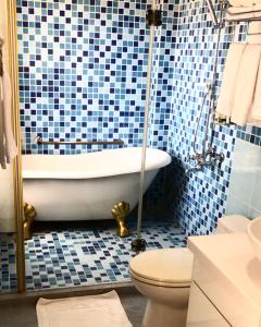 冬山鄉的住宿－四季花園民宿 宜蘭羅東民宿，带浴缸和卫生间的浴室以及蓝色瓷砖。