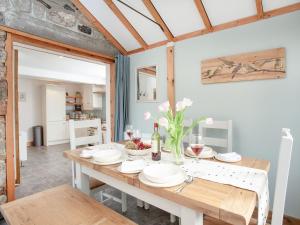 cocina y comedor con mesa de madera en The Coach House, en South Zeal