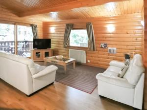 a living room with two white couches and a tv at Haven Lodge in Legbourne