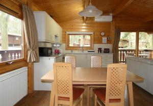 a kitchen with a table and chairs in a cabin at Haven Lodge in Legbourne